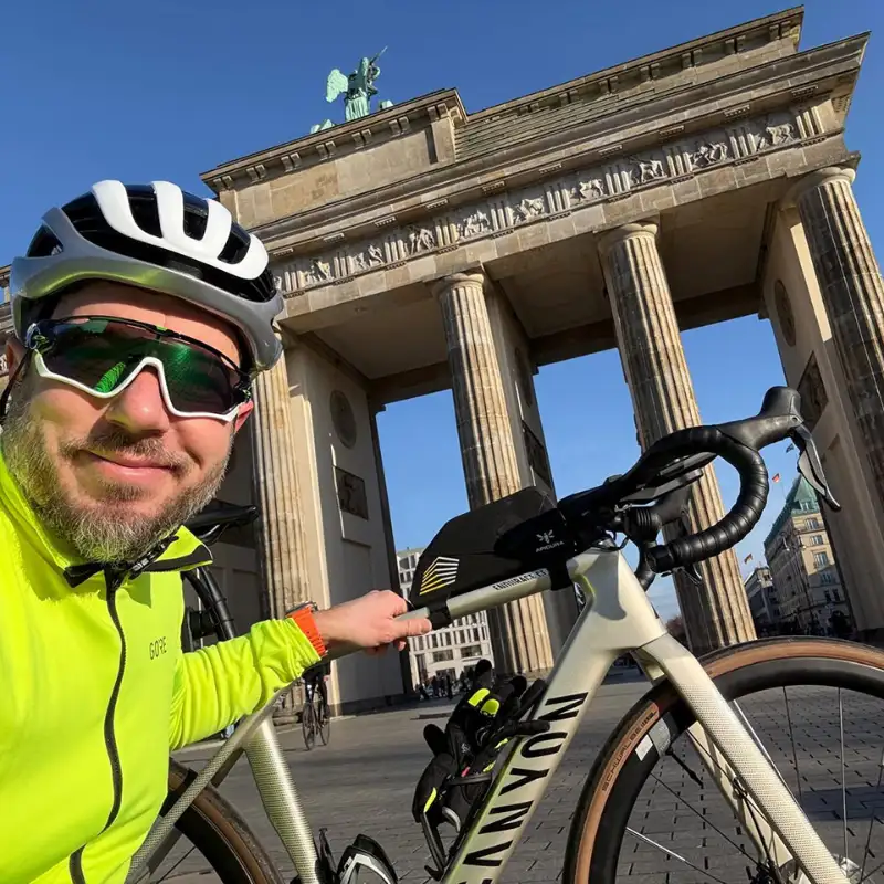Der CEO der FocusNet GmbH, Ryszard Szklany, steht mit seinem JobRad grinsend vor dem Brandenburger Tor in Berlin bei blauem Himmel. Der CEO der FocusNet GmbH, Ryszard Szklany, steht mit seinem JobRad grinsend vor dem Brandenburger Tor in Berlin bei blauem Himmel.
