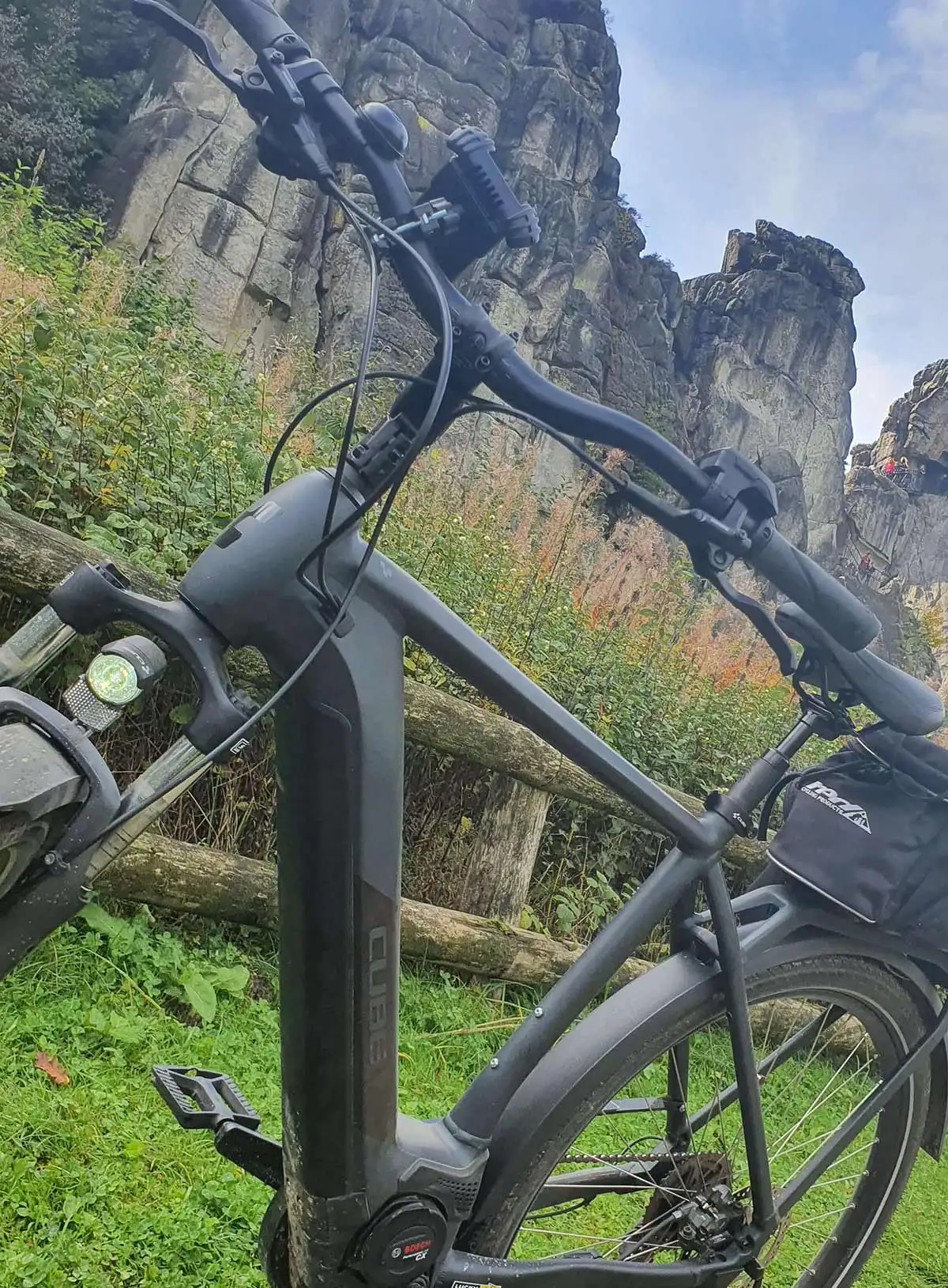 Ein schwarzes Fahrrad auf grünem Gras zwischen den Bergen Ein schwarzes Fahrrad auf grünem Gras zwischen den Bergen